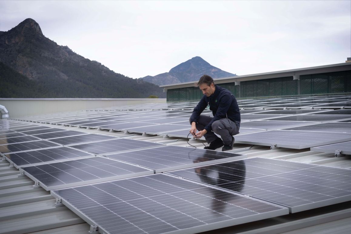Trabajador de Mercadona en una cubierta de una tienda con paneles solares Trabajador de Mercadona en una cubierta de una tienda con paneles solares