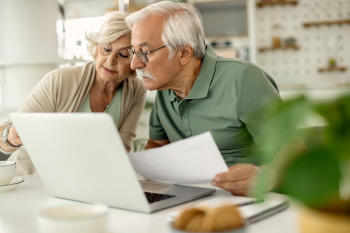 pareja mayor analizando sus ahorros mientras revisa finanzas hogar